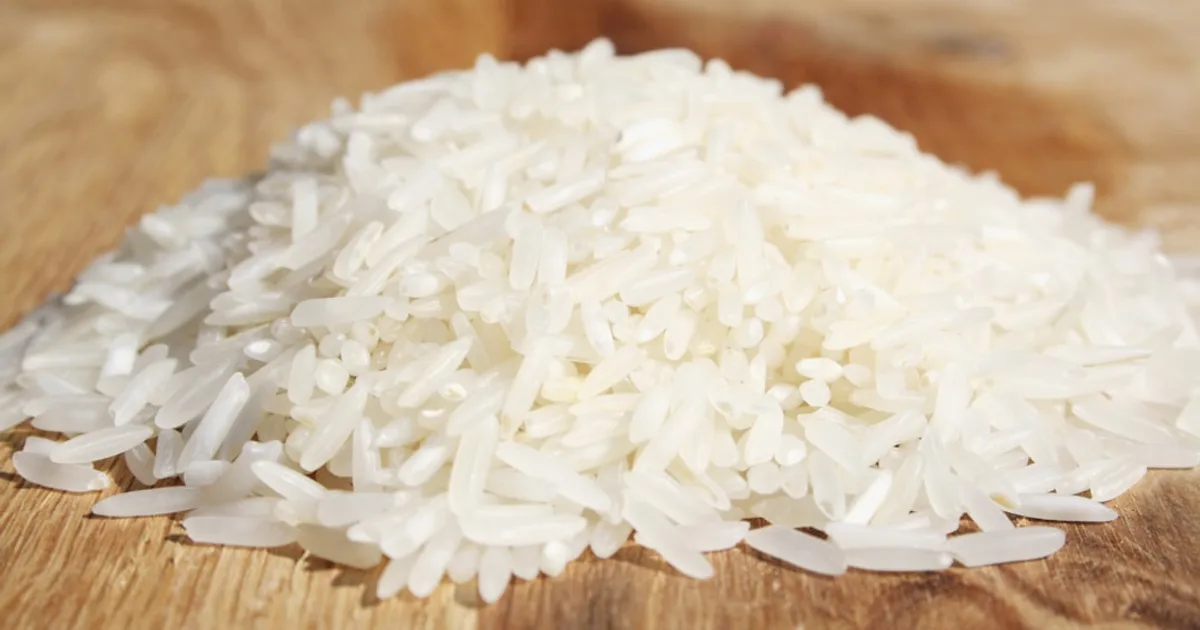 A pile of rice sitting on top of a wooden cutting board