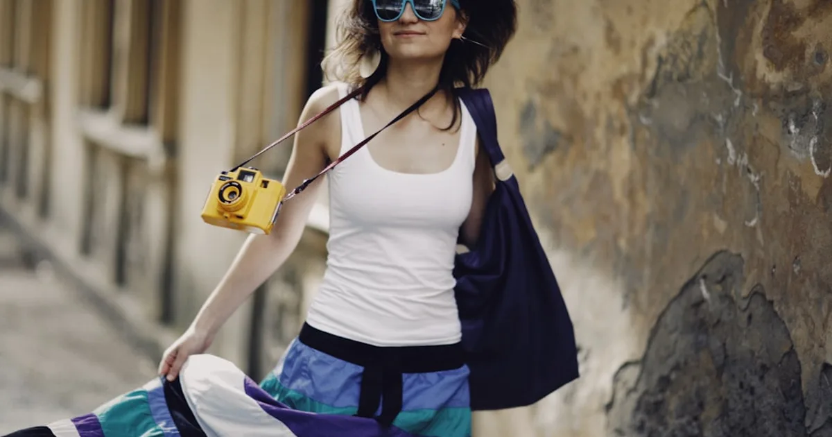 a woman with a camera is walking down the street
