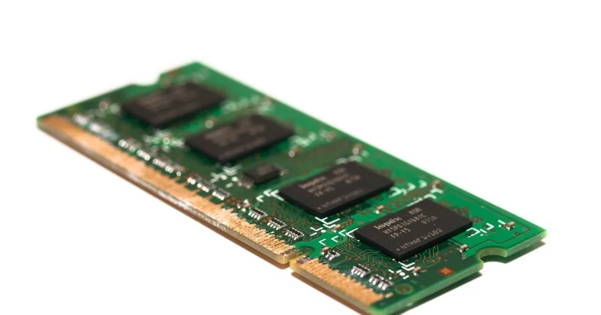 Detailed view of a green electronic memory module against a white background, showcasing modern technology.