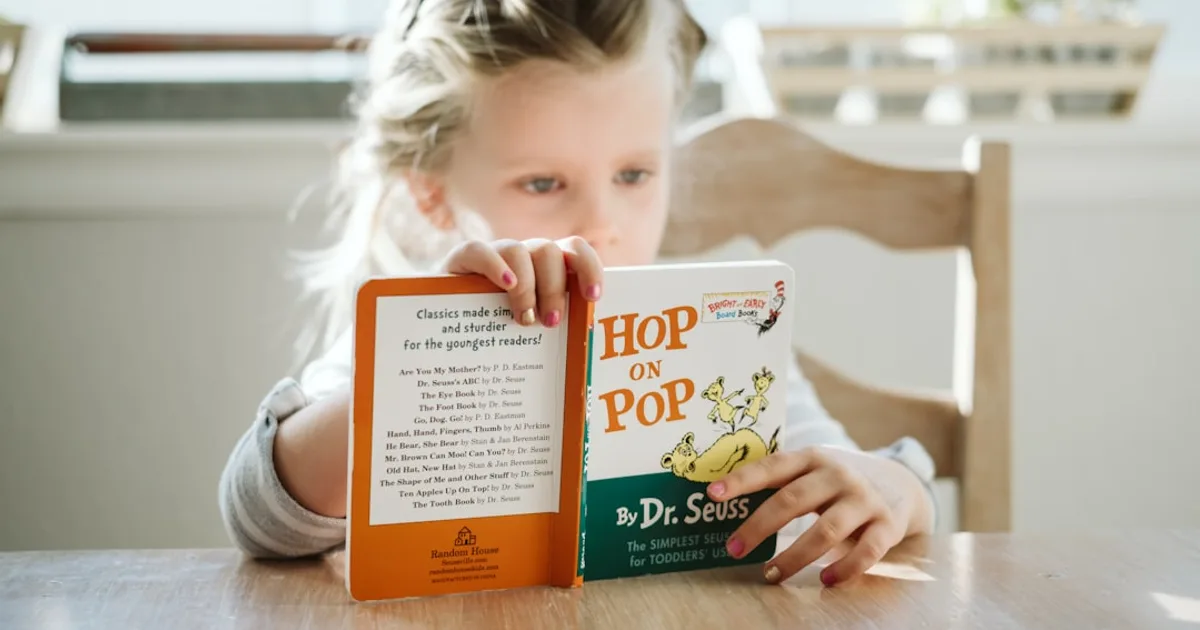 girl sitting while reading book