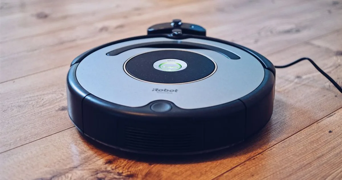 Close-up of a robotic vacuum cleaner operating on a hardwood floor, showcasing modern cleaning technology.